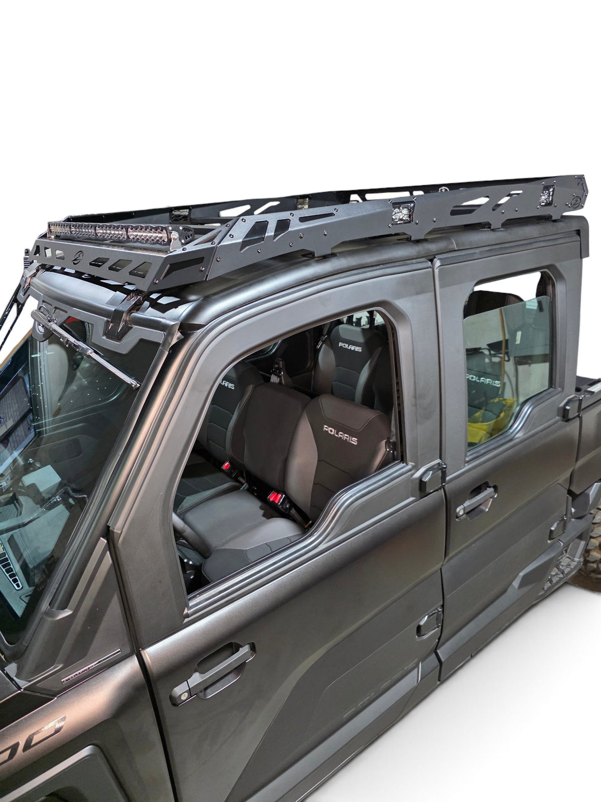 Front side view of the installed roof rack with a light bar mounted on the front rail