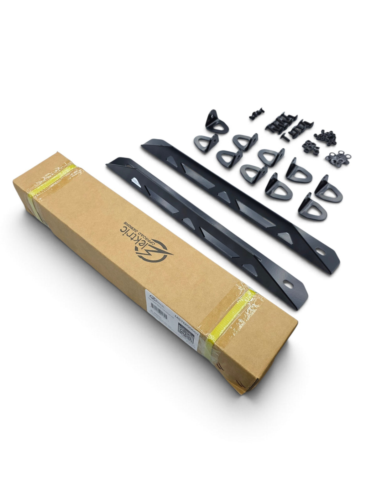 Roof rack tie down kit in its box with the tie-down points, E-Track mounts, and hardware laid out beside it